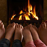 Family warming feet by fire